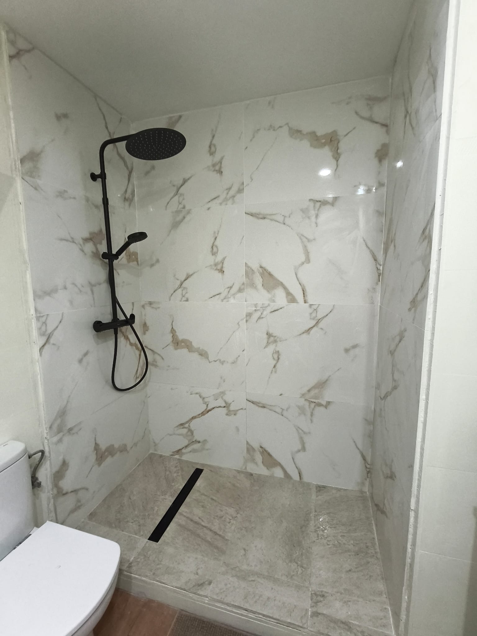 Ducha de mármol con grifería negra