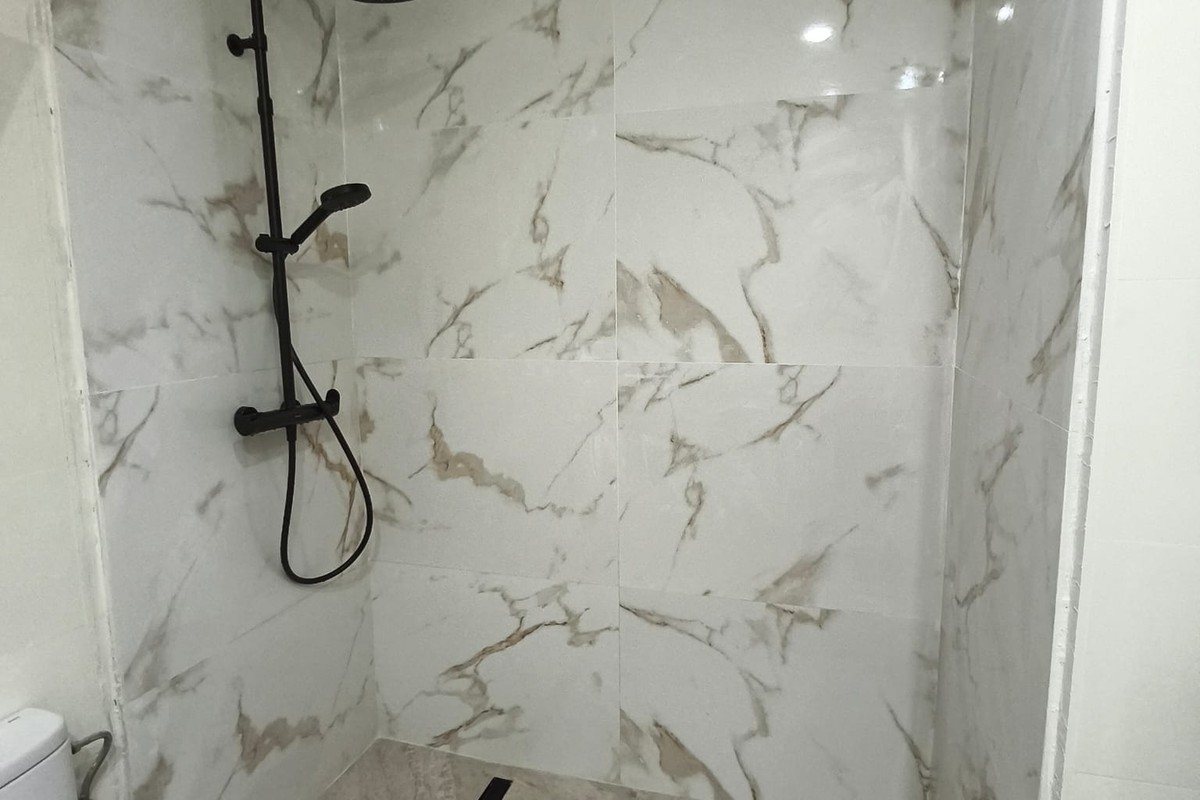 Ducha y baño terminado con porcelánico y grifería